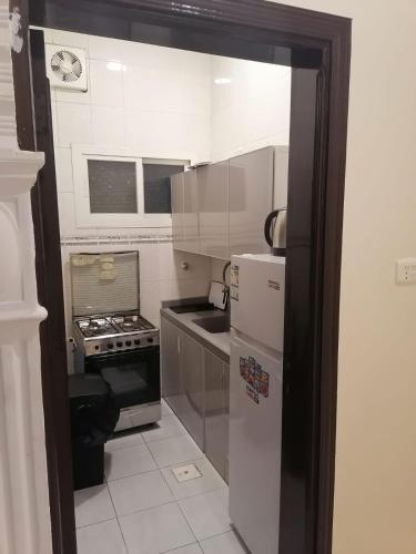 a small kitchen with a refrigerator and a stove at فخامة المصيف للشقق المخدومة 2 in Taif