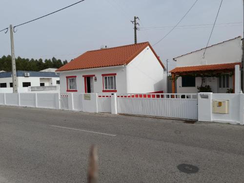 a white fence in front of a white house at Casa Baptista II in Marinha Grande