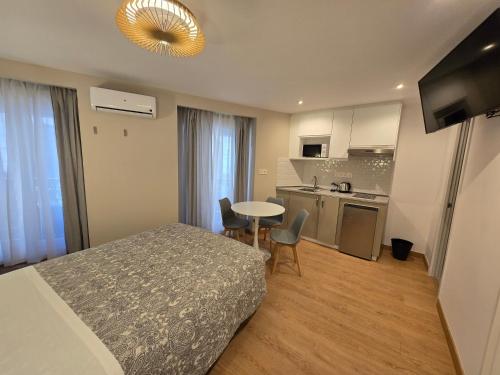 a bedroom with a bed and a table and a kitchen at Hostal Comercial in Madrid