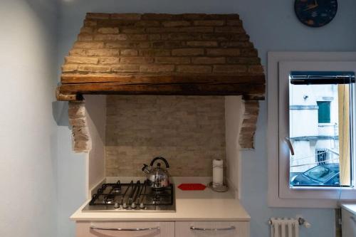 a kitchen with a stove top oven in a kitchen at La Casa Gialla in Chioggia