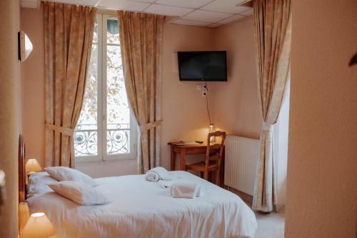 a hotel room with a bed and a window at Hôtel De France in Chalabre
