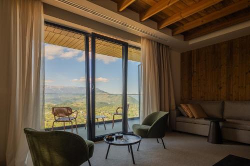 a living room with a large window with a view at The Pines Bucegi Lodge in Bran