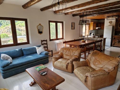 a living room with a couch and chairs and a table at Chalet Catalan proche des pistes in Porta