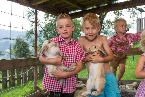 a group of young children holding baby animals at Appartements Lehenhof in Sankt Johann im Pongau