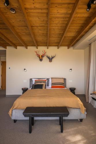 a bedroom with a bed with two antlers on the wall at The Pines Bucegi Lodge in Bran