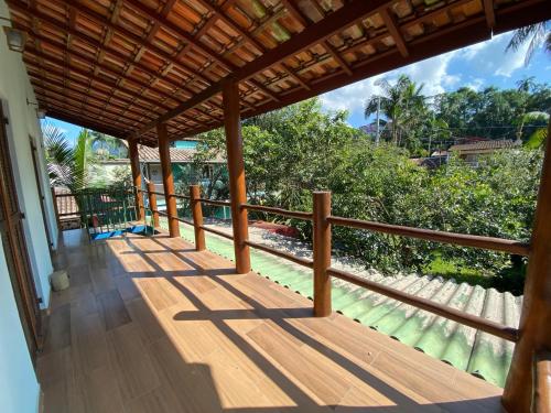 Un balcón de una casa con barandilla de madera. en Íkaia Surf House, en Ubatuba