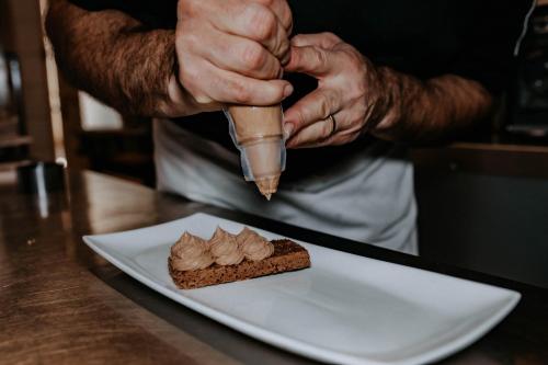 a person is sprinkling peanut butter on a piece of food at Hôtel De France in Chalabre
