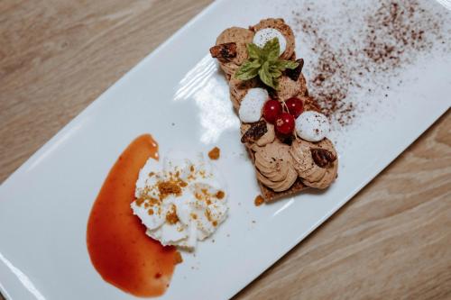 a plate of food with a banana and dessert at Hôtel De France in Chalabre