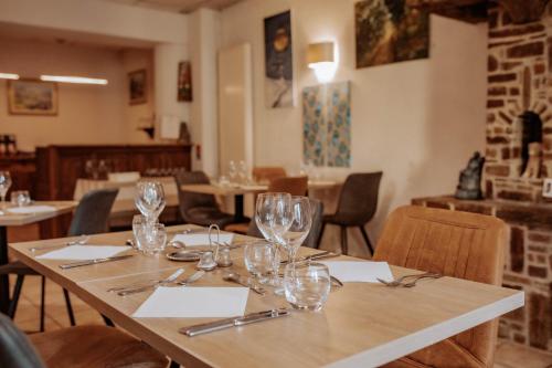 a table in a restaurant with wine glasses on it at Hôtel De France in Chalabre
