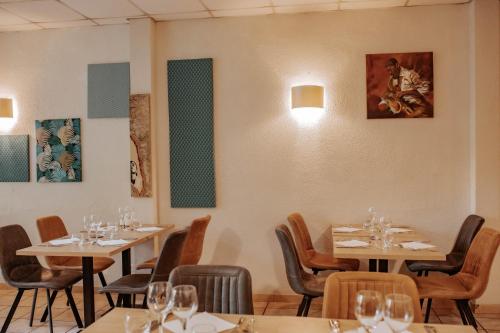 a restaurant with tables and chairs with wine glasses at Hôtel De France in Chalabre