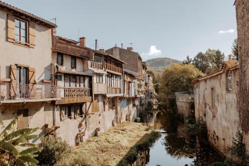 an alley in an old town with a river at Hôtel De France in Chalabre
