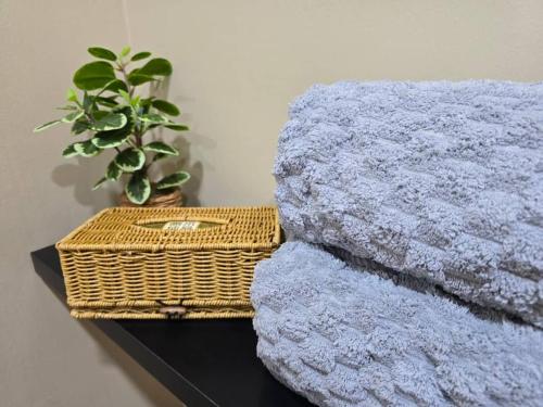 a pile of blankets on a table with a basket at Qaira Eco Homestay in Kota Kinabalu