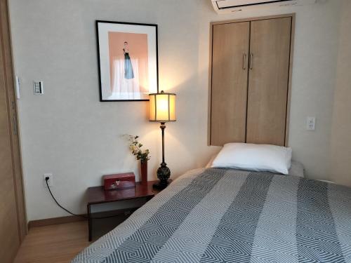 a bedroom with a bed and a lamp and a cabinet at 源氏民宿 in Tokyo