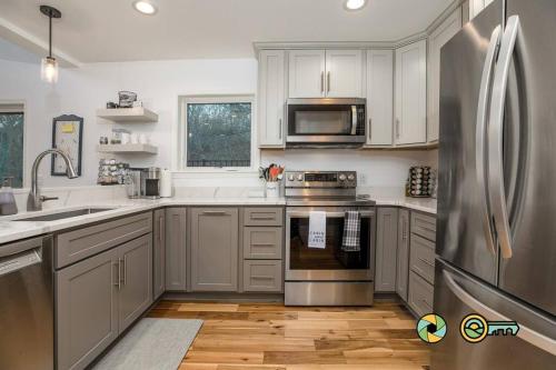 a kitchen with white cabinets and a stainless steel refrigerator at The Swirling Bird in Basye