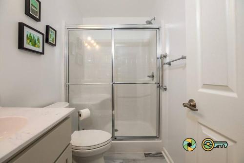 a white bathroom with a shower and a toilet at The Swirling Bird in Basye