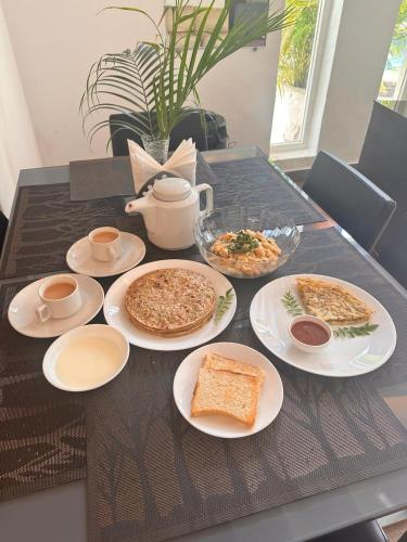 a table with plates of food on top of it at VILLA M- SAVANNAH 7- 5BHK Brand New Villa in Calangute with Private Pool, Near Beach, free Breakfast, north goa in Goa