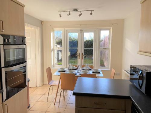 a kitchen with a table with chairs and a dining room at Johnson Townhouse in Wellingborough