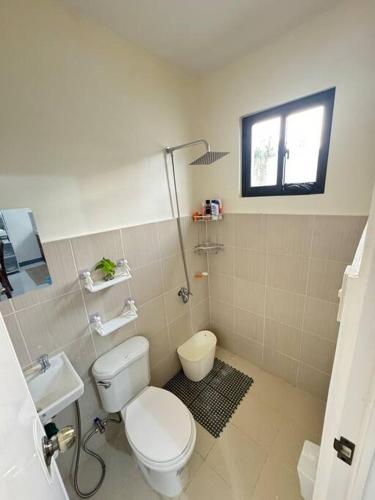 a bathroom with a toilet and a sink at Staycation Calaca in Calaca