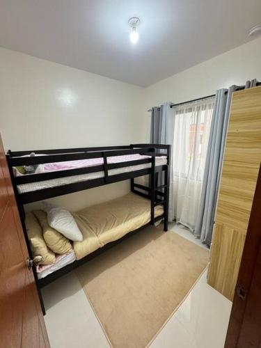 a room with two bunk beds in a room at Staycation Calaca in Calaca