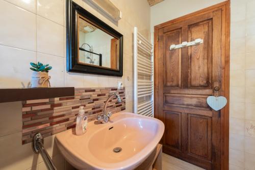 a bathroom with a sink and a wooden door at Gite La Pondique in Escot