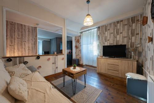 a living room with a couch and a tv at Gite La Pondique in Escot