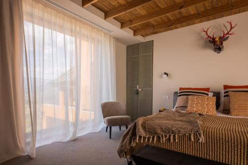 a bedroom with a bed and a large window at The Pines Bucegi Lodge in Bran