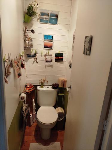 La salle de bains est pourvue de toilettes blanches et de photos murales. dans l'établissement Cosy House, à Quimper