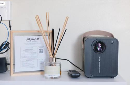 a desk with a camera and a vase with sticks at Cityscape Grand in Cebu City