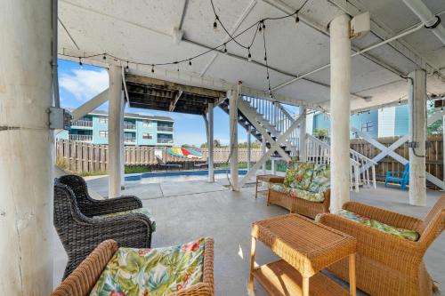 a patio with chairs and a table and a staircase at Surfs Up in Gulf Shores