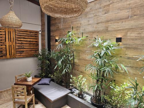 a room with a table and a bench and plants at Hotel Fabris in Nova Friburgo