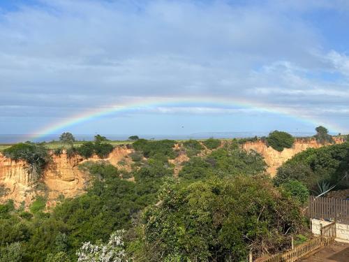 a rainbow in the sky over a mountain at Canyon View Self Catering unit in Groot Brak Rivier