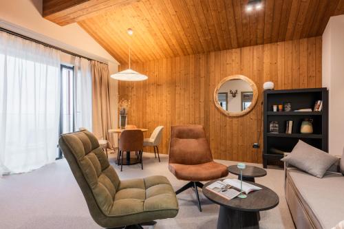 a living room with a couch and chairs and a table at The Pines Bucegi Lodge in Bran