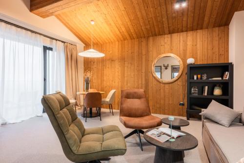 a living room with a couch and chairs and a table at The Pines Bucegi Lodge in Bran