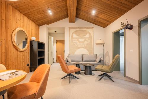 a living room with a couch and chairs and a table at The Pines Bucegi Lodge in Bran