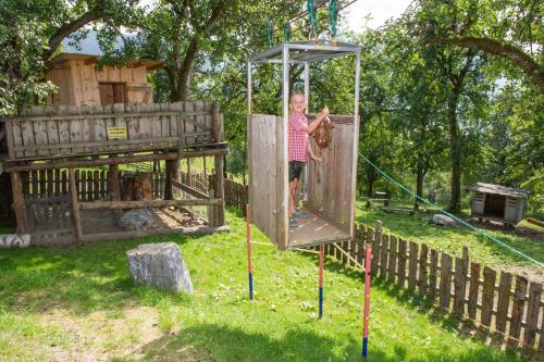 a man is on a playground in a park at Appartements Lehenhof in Sankt Johann im Pongau
