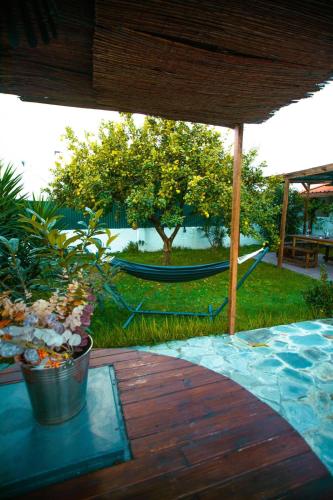 a patio with a hammock and a table with plants at Poolemonhouse in Fernao Ferro