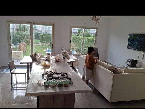 a woman is standing in a living room at New villa on the marina sea in Ash Shihābīyah