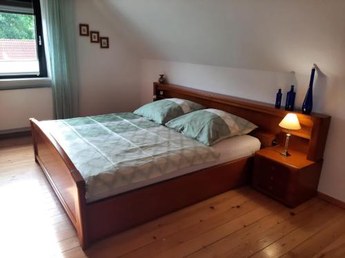 a bedroom with a bed with a wooden headboard and a lamp at Ferienwohnung Schäffer in Regensburg