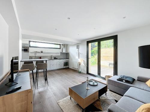 un salon avec un canapé et une table dans l'établissement Le Secret de Medan - Jardin - parking PV - Paris, à Médan