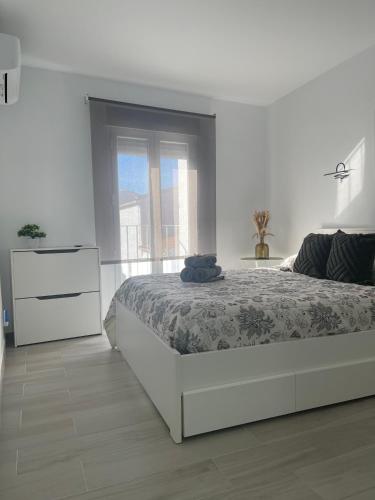 a white bedroom with a bed and a dresser at Apartamento Victoria Deluxe in Fuente Obejuna