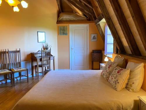 a bedroom with a bed and a table and chairs at Le Chateau de Busqueilles La Suite in Autoire