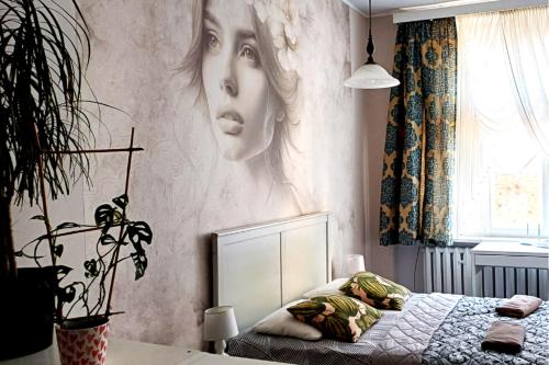 un dormitorio con un cartel de una mujer en la pared en Cozy Old Town Apartments, en Cracovia