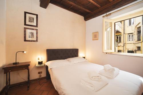 a bedroom with a bed with towels on it at Trevi Fountain by BuddyRent in Rome