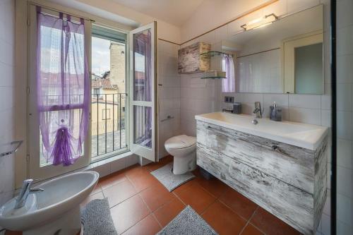 a bathroom with a sink and a toilet and a window at Oasi in centro Bergamo - terrazza privata in Bergamo