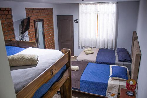 a bedroom with two beds and a window at Huacachina Desert House in Ica