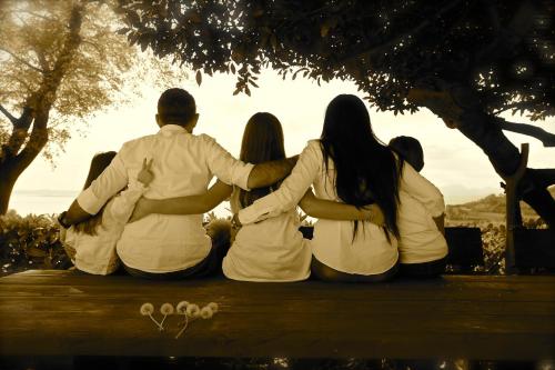 a group of people sitting on a bench under a tree at 3V UGO WHIT POOL apartment Bardolino in Bardolino