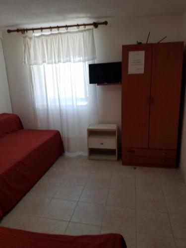 a bedroom with a bed and a cabinet and a window at Casadelpino Residence La Piana in Ponza