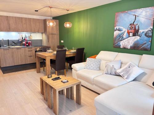 un salon avec un canapé blanc et une cuisine dans l'établissement Les Gets: Appartement 2 ch. avec terrasse et WIFI, proche centre et pistes - FR-1-623-309, aux Gets
