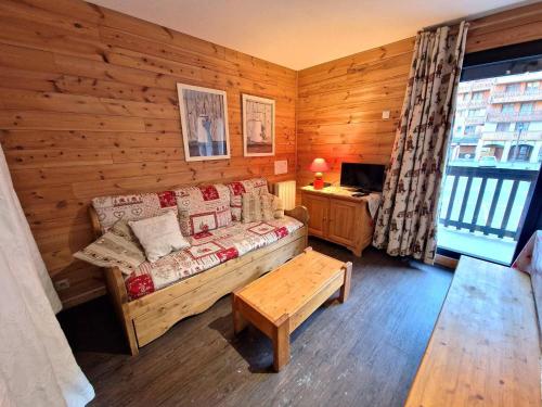 Cette chambre comprend un canapé et une table. dans l'établissement 2 Pièces+Cabine, 6-8 Pers, 42m², Coeur Station, Près Pistes, TV, DVD - FR-1-265-220, à Valfréjus