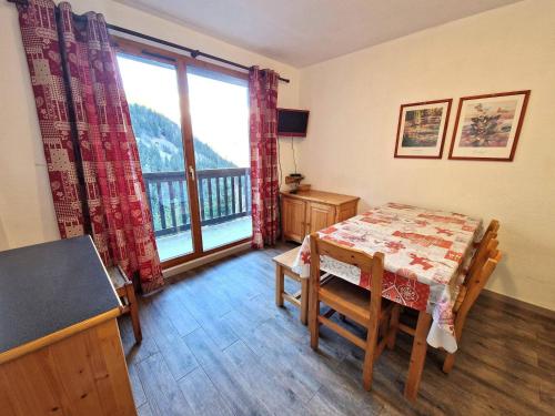 une salle à manger avec une table et une grande fenêtre dans l'établissement Charmant 2 pièces + cabine, 4/6 pers, au cœur de Modane, 32m², proche pistes et commerces - FR-1-265-250, à Valfréjus